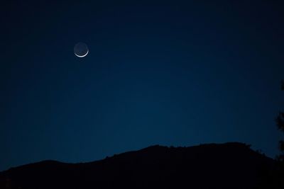 Low angle view of silhouette mountain against sky at night