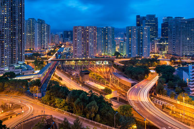 High angle view of illuminated street amidst buildings in city at night