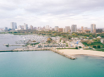 High angle view of sea by city against sky