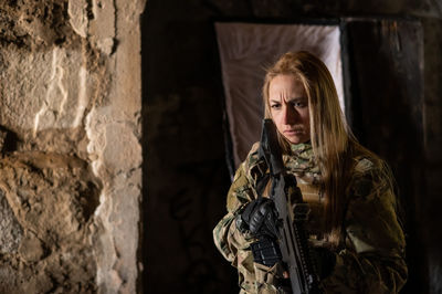 Portrait of woman standing against wall