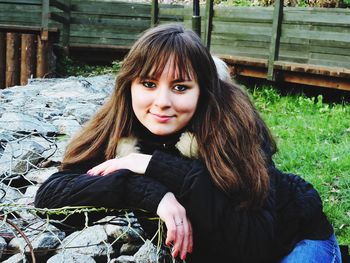 Portrait of smiling young woman sitting outdoors