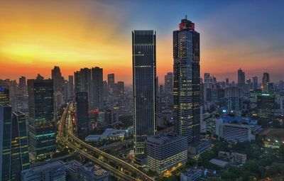 High angle view of illuminated cityscape against sky during sunset