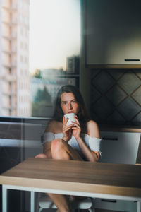 Portrait of a young woman drinking glass