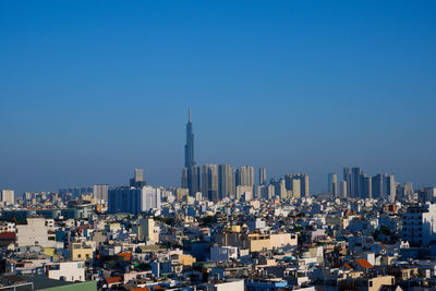 Modern buildings in city against clear blue sky
