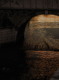 Arch bridge over river against wall