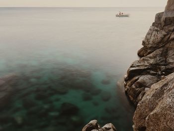 Close-up of rock in sea against sky