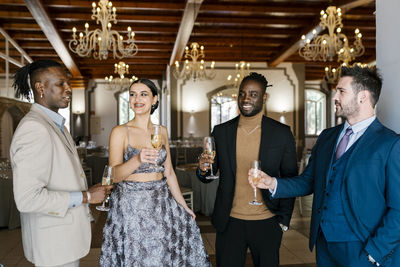 Elegant men and woman holding champagne flute at banquet