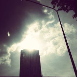 Low angle view of modern building against cloudy sky