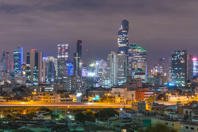 Illuminated buildings in city against sky