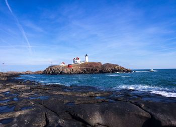 Rocky sea shore against blue sky