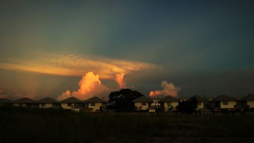 Houses against sky during sunset