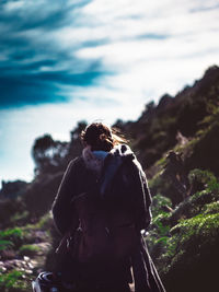 Rear view of woman on mountain against sky