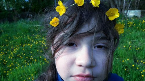 Close-up portrait of girl with yellow flowers