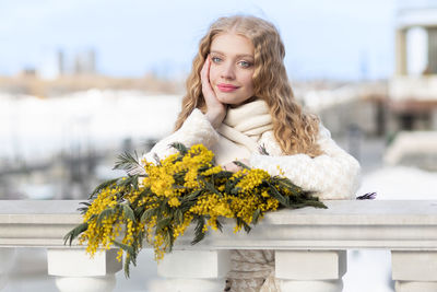 A woman with a bouquet of yellow acacia flowers. spring holiday - march 8, easter, women's day