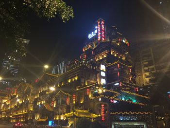 Low angle view of illuminated buildings against sky at night