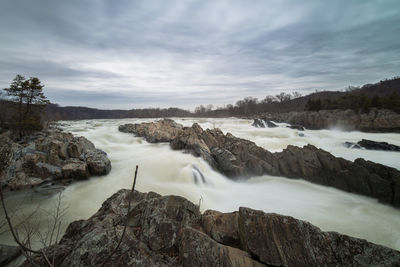 Scenic view of waterfall against sky