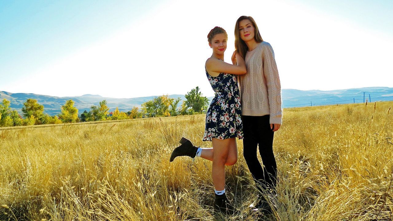 young adult, person, casual clothing, lifestyles, leisure activity, full length, standing, sky, young women, field, clear sky, front view, landscape, portrait, smiling, looking at camera, three quarter length, nature