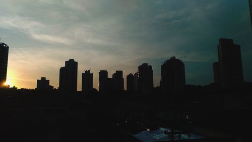 Skyscrapers in city at sunset