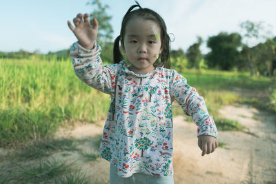 Portrait of cute girl with bandages on face standing on land