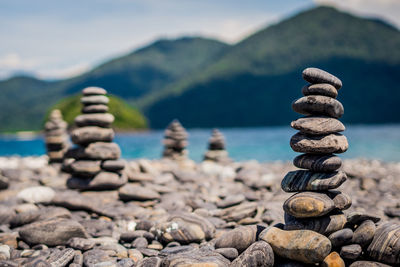 Stone stack at lakeshore against mountains