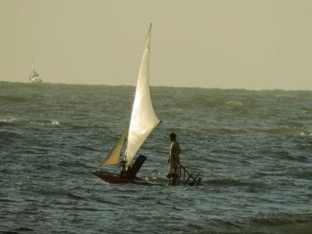 Men on sea against sky