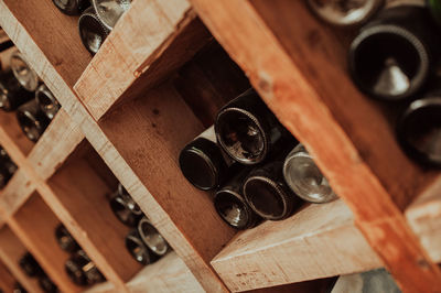 Dark wooden storage cabinet for bottle with plenty of empty bottled glass