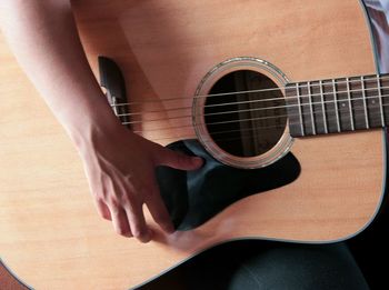 Low section of woman playing guitar