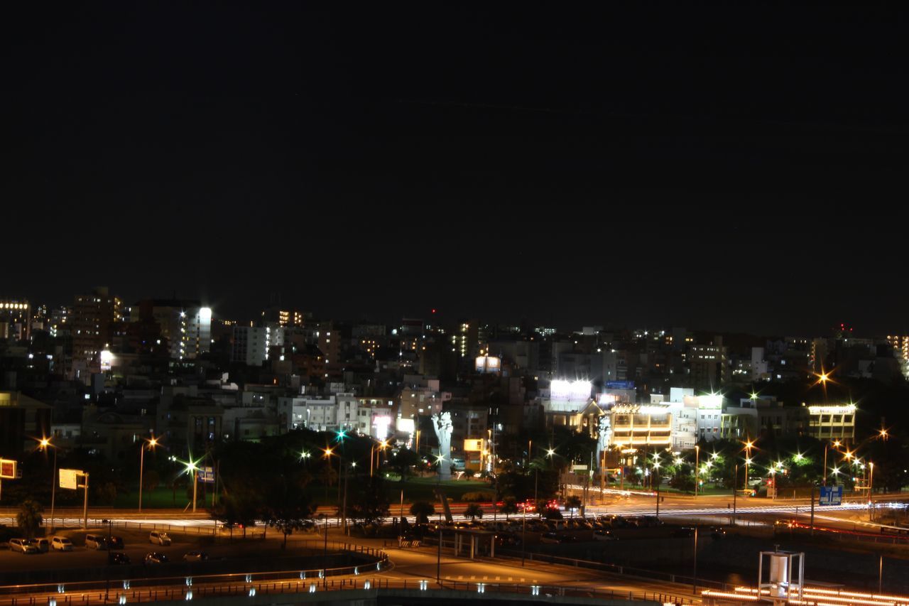 HIGH ANGLE VIEW OF ILLUMINATED STREET AMIDST BUILDINGS IN CITY