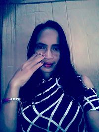 Portrait of woman standing against wall