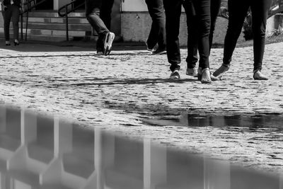 Low section of people walking on footpath in city