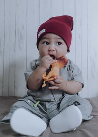 Portrait of cute boy eating while sitting outdoors