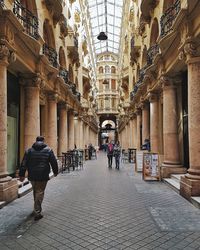 Rear view of people walking in historic building