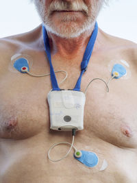 Senior man with long-term ecg on his chest, close up