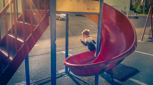 Boy running by slide at playground