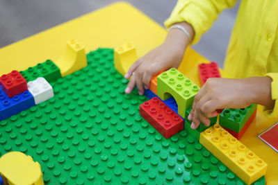 Midsection of girl playing with toy blocks