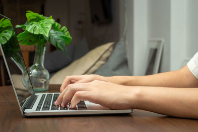 Midsection of woman using laptop on table