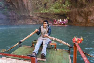 Portrait of smiling young couple sitting on water