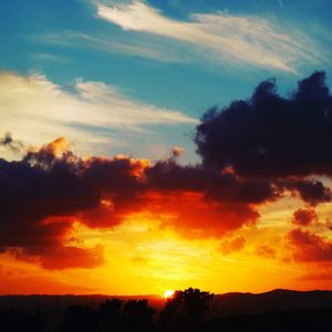 Scenic view of silhouette landscape against orange sky