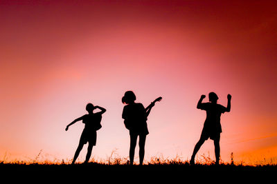 Silhouette people standing against clear sky during sunset