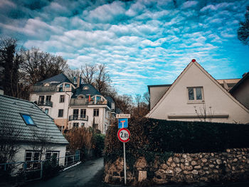 Road by buildings against sky