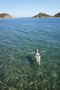 High angle view of woman floating in sea