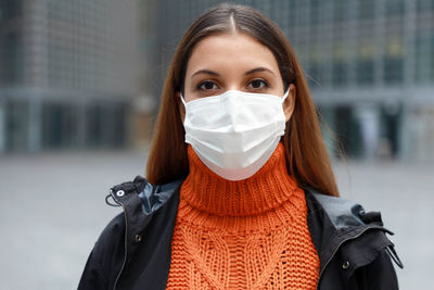 Portrait of beautiful woman wearing mask standing outdoors