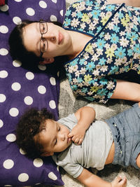 High angle view of baby girl lying on woman