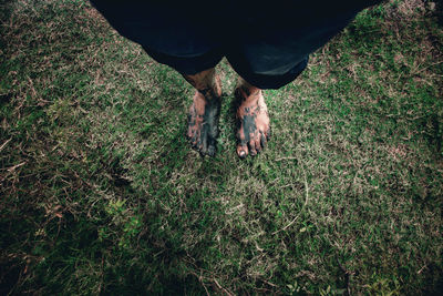 Low section of man standing on field