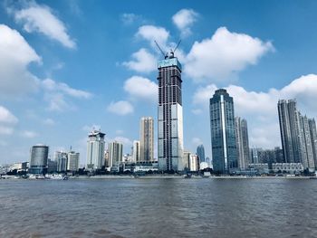 Modern buildings in city against cloudy sky