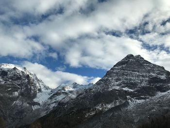 Low angle view of snowcapped mountains against sky