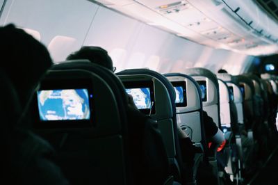 Rear view of people on seats in airplane