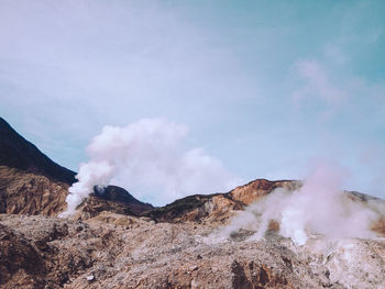 Smoke emitting from volcanic mountain against sky