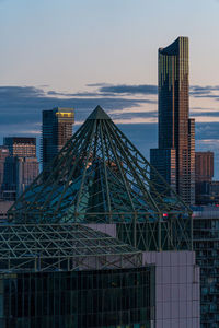 Modern buildings against sky during sunset in city