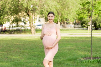 Pregnant woman standing in park